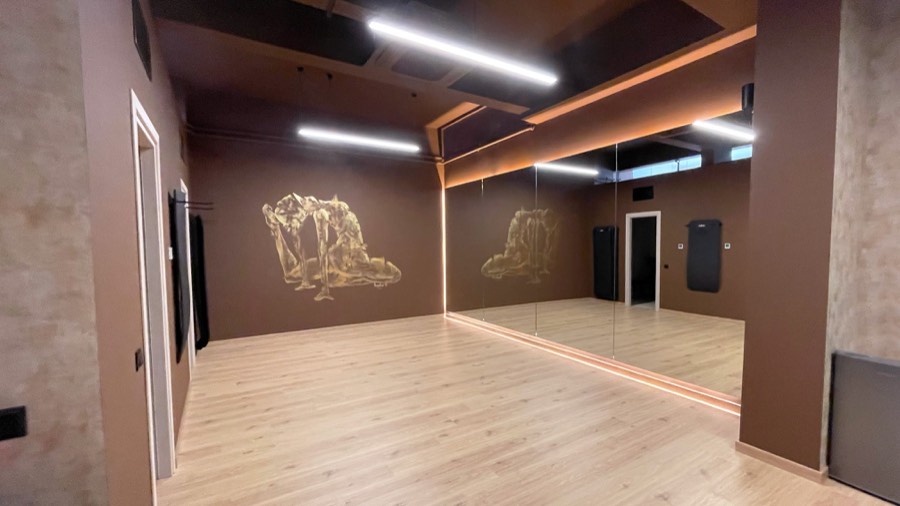 Η αίθουσα mat και yoga με τη χρυσή τοιχογραφία και τους καθρέφτες